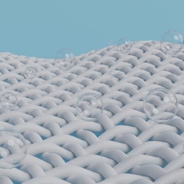 Close-up of white woven mesh fabric with small, evenly spaced holes and transparent bubbles on its surface.