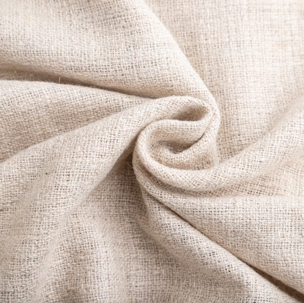 Close-up image of beige plain weave cotton fabric, showing its soft texture and fine weave pattern with slight wrinkles.