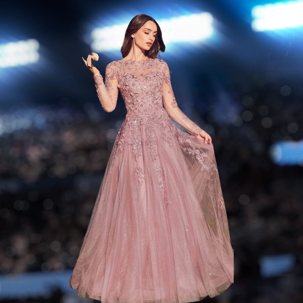 A woman in an elegant, pink lace gown standing against a blurred, illuminated outdoor background at night.