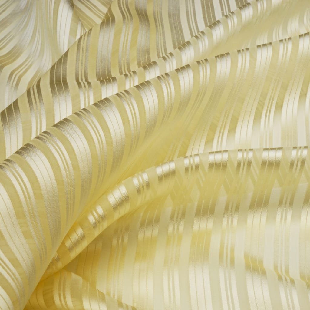 Close-up view of silk organza fabric featuring various shades of cream and gold with intricate striped and wavy patterns.