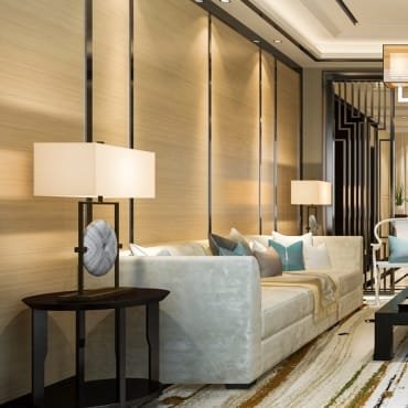Elegant living room with a plush velvet sofa, modern table lamps, and a stylish wall with vertical lighting accents, creating a sophisticated ambiance.
