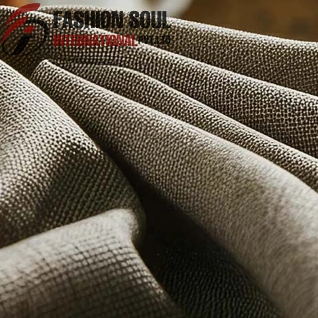 Close-up of folded fabric with a textured, dotted pattern in shades of brown and beige.