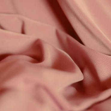 Close-up of soft pink cotton velvet fabric with a smooth, plush surface and subtle sheen.