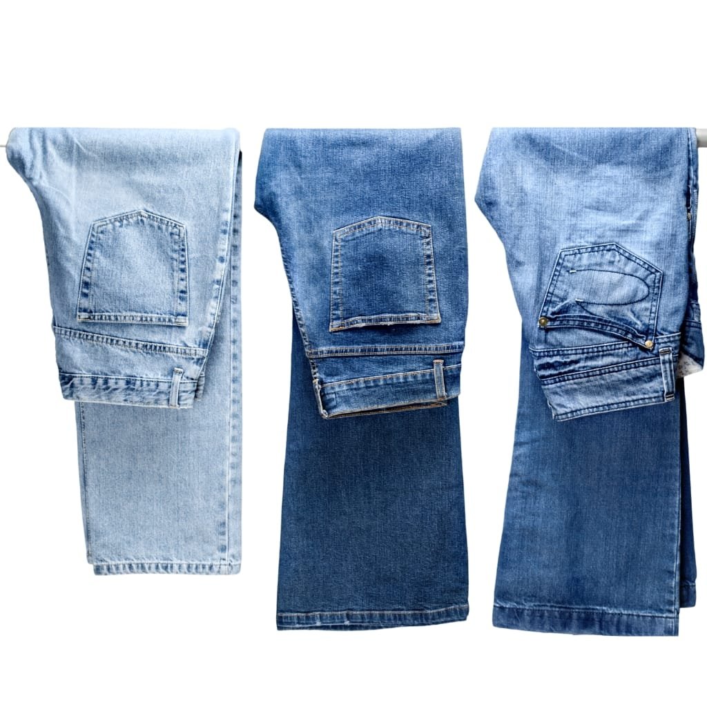 Three pairs of folded denim jeans in different shades of blue, arranged side by side on a white background.