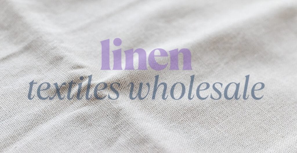 Close-up photo of a piece of linen fabric with soft, natural textures. Overlaid on the fabric are the words "linen textiles wholesale" in purple and blue cursive fonts.
