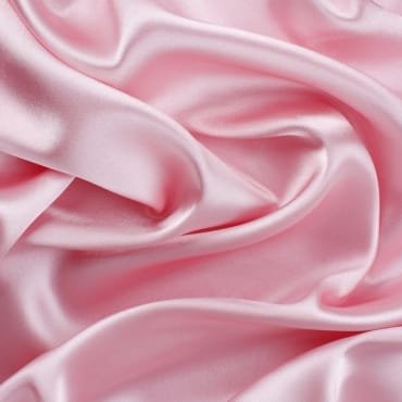 Close-up of soft pink silk velvet fabric with a smooth, lustrous, and luxurious surface.