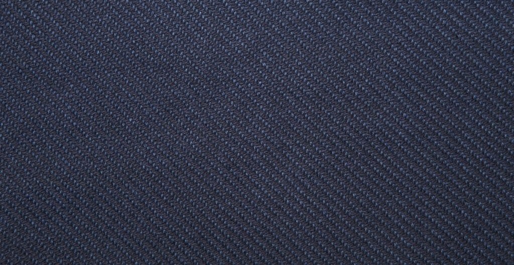 Close-up image of dark blue twill weave cotton fabric, showing the diagonal rib pattern.
