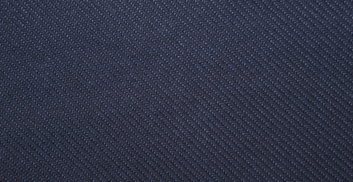 Close-up image of dark blue twill weave cotton fabric, showing the diagonal rib pattern.