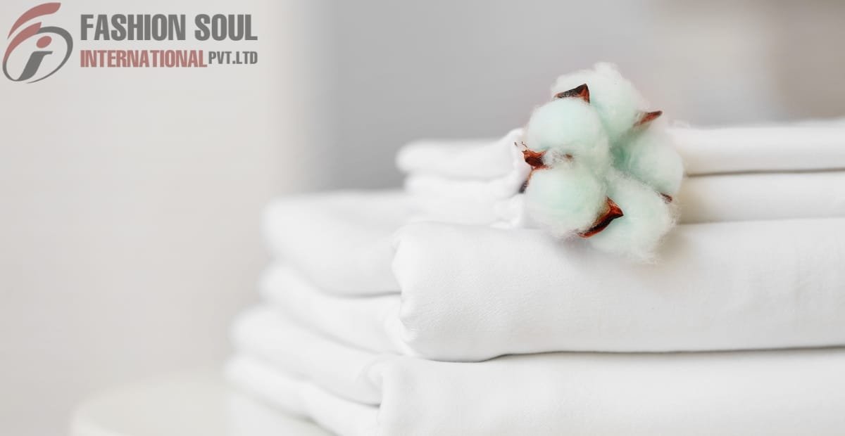 Packaged white fabric with a cotton flower on top, featuring the logo and text "Fashion Soul International Pvt. Ltd." in the upper left corner.