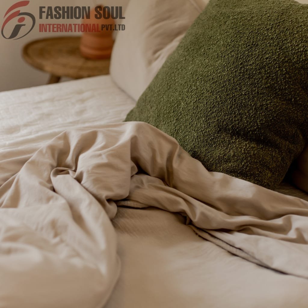 Neutral-toned bed sheet bundle with green textured cushion on a cozy bed setup.