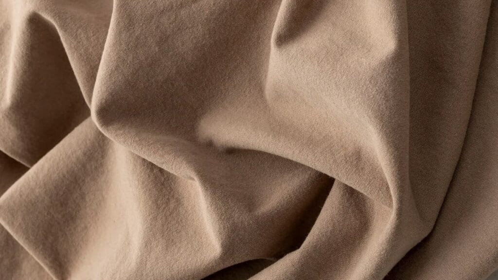 A close-up view of sturdy, plain-weave cotton canvas fabric with a smooth, tight weave and a natural off-white color.
