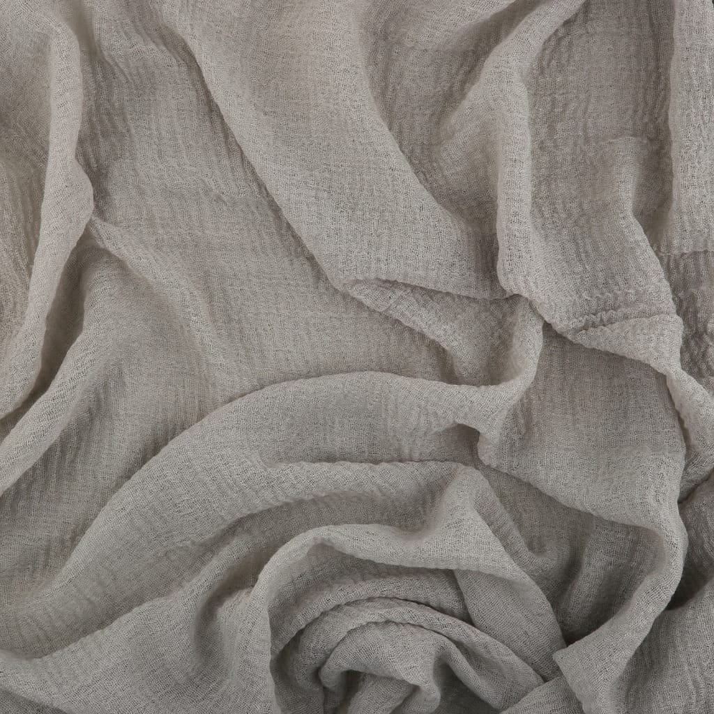 Close-up of light-colored, textured fabric with soft, flowing folds and creases.