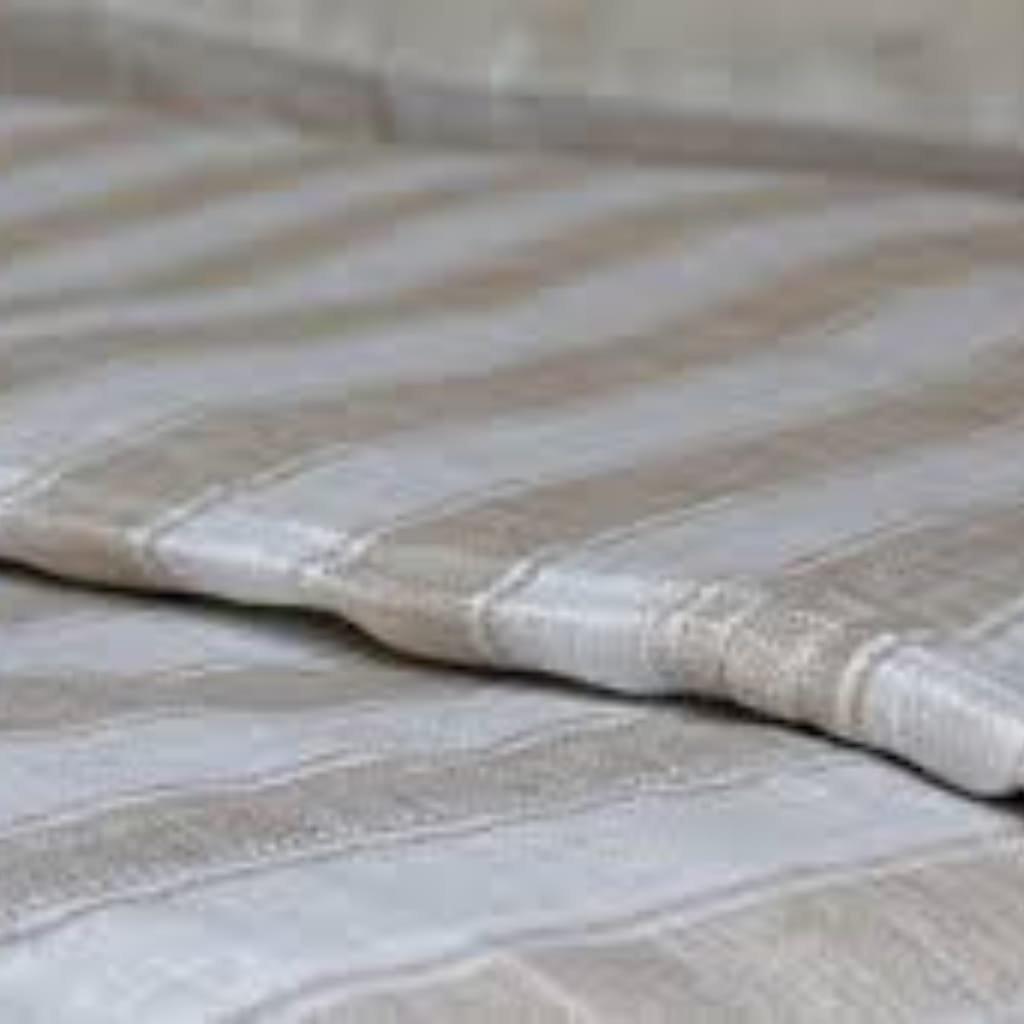 Close-up of a soft, beige and gray striped fabric surface, likely a bedspread or blanket.