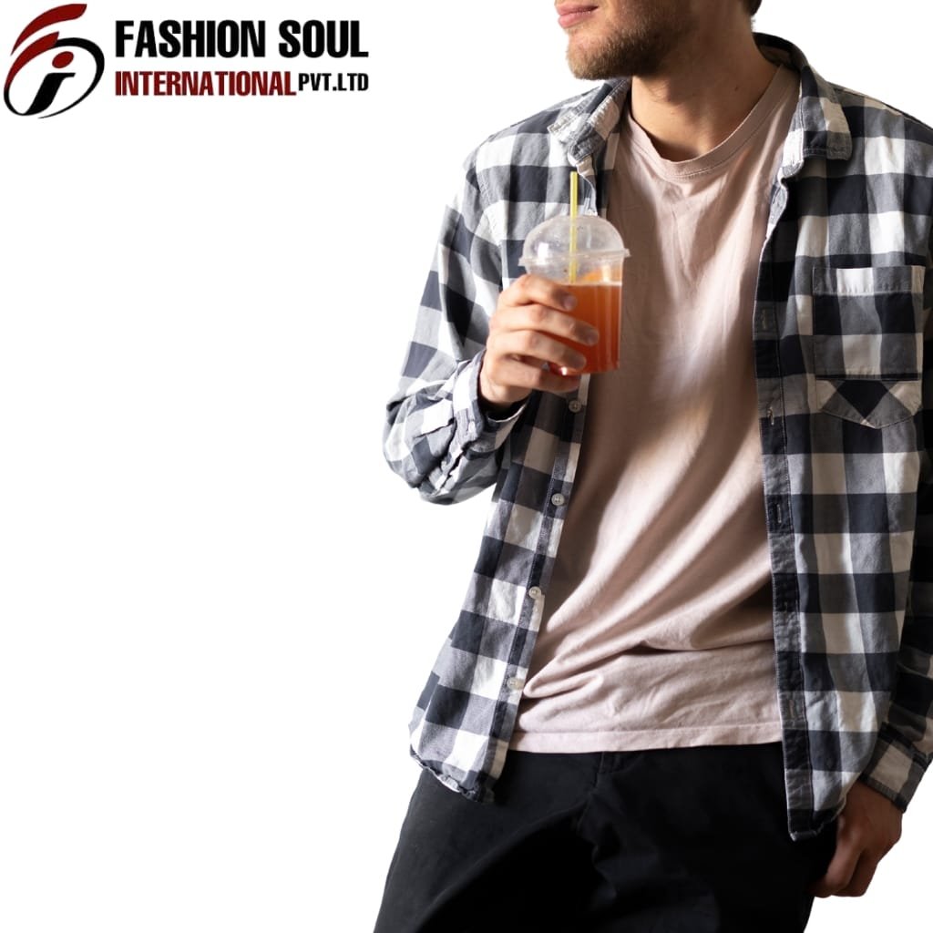  A man dressed in a casual checkered shirt over a beige T-shirt holds a plastic cup with a straw, which contains an orange-colored beverage. Only the lower part of his face and his upper body are visible, with his leisure stance and relaxed outfit.