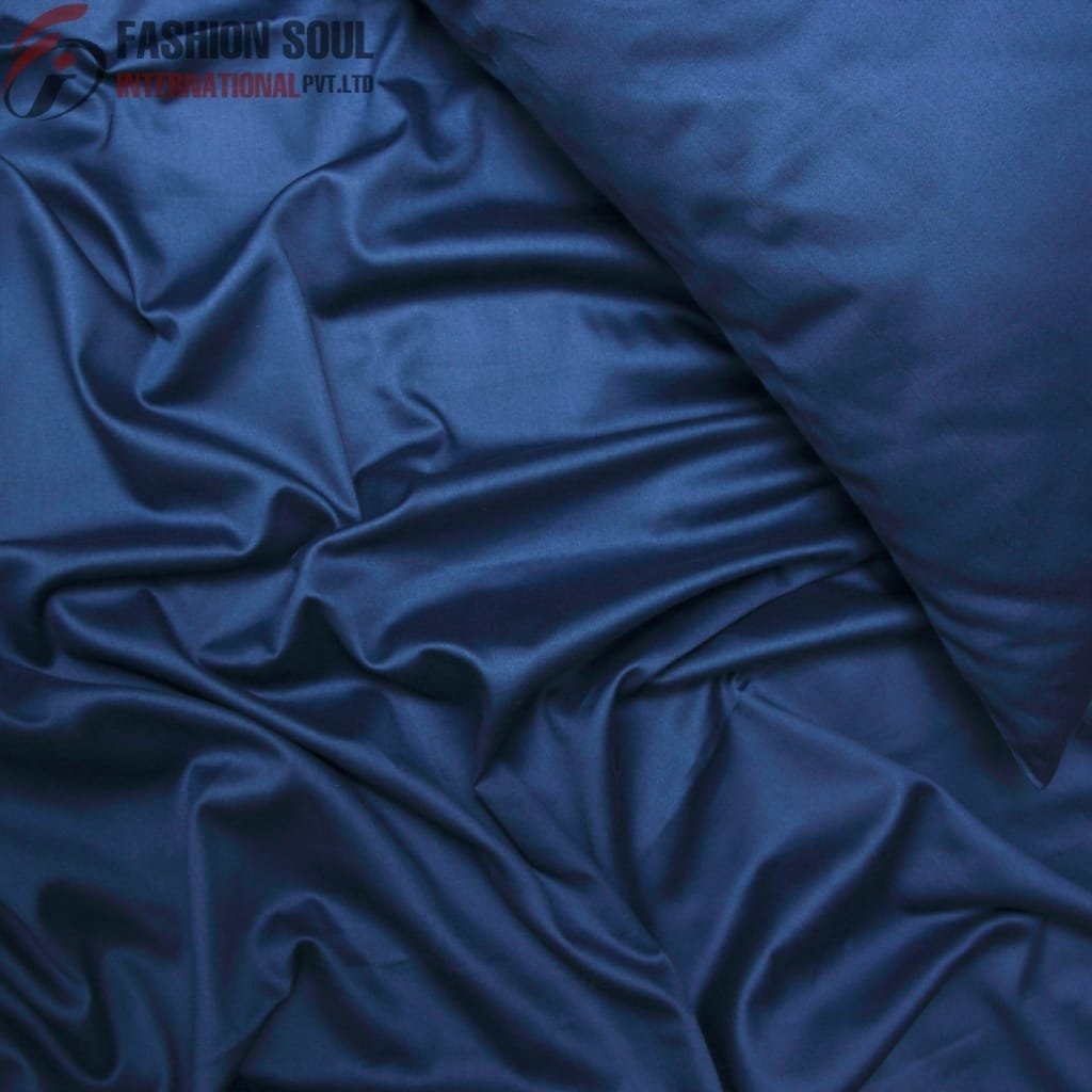 A close-up image of smooth, shiny, dark blue satin fabric with soft wrinkles and folds.