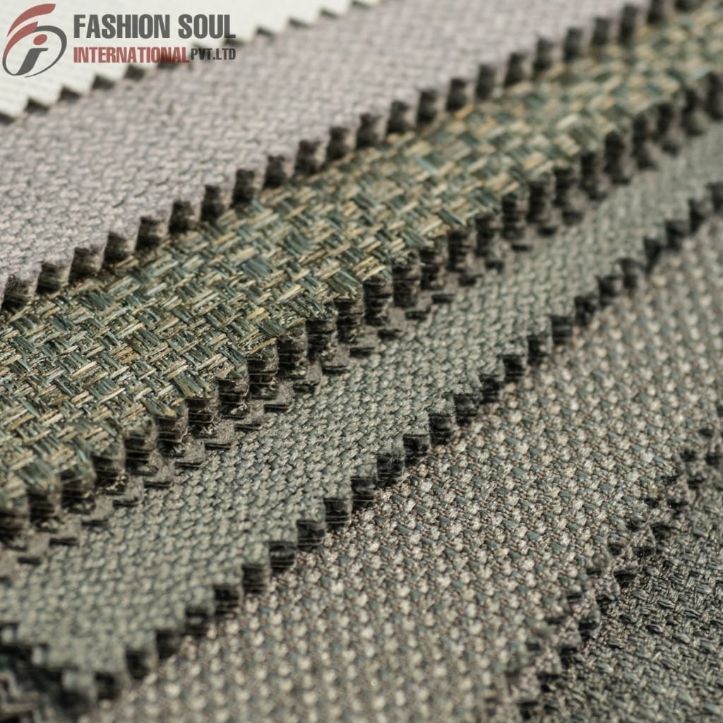  Close-up of several fabric swatches with a textured weave, showcasing different shades of grey and green, with the "Fashion Soul International Pvt. Ltd" logo in the top left corner.