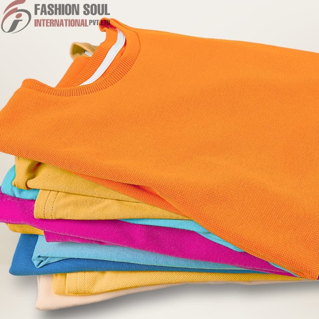 Stacked colorful sweatshirts or t-shirts in shades of orange, yellow, pink, blue, and beige, folded neatly.