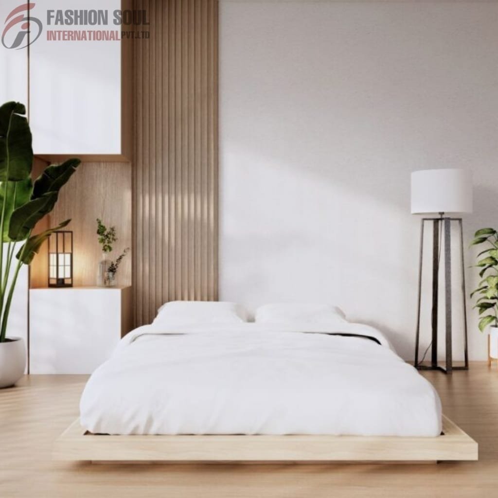 A minimalist and modern bedroom featuring a low-profile wooden bed with white bedding, flanked by a tall black floor lamp and a white nightstand with a small plant. Large green plants add a touch of nature, and there is a vertical wooden panel behind the bed, enhancing the room's warm, neutral tones.