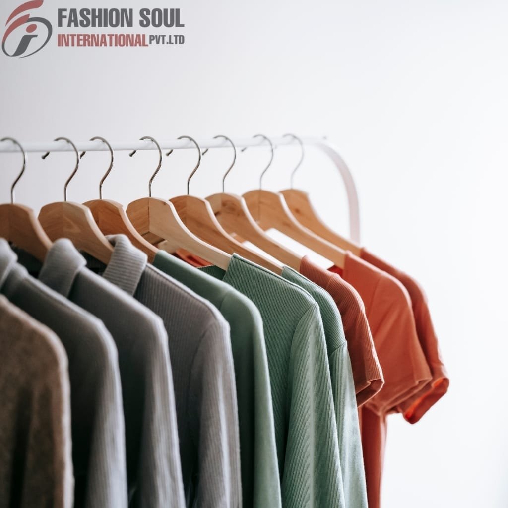 A row of colorful shirts hanging on wooden hangers on a white clothing rack, with a plain white background and the "Fashion Soul International" logo in the top left corner.