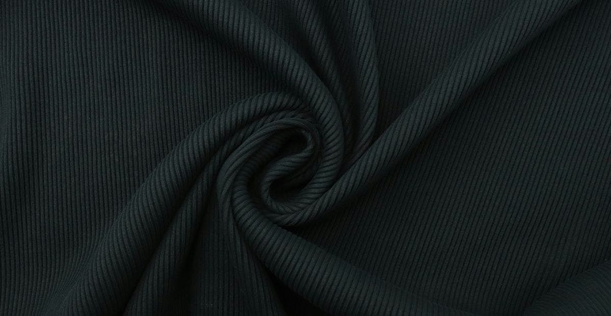 Close-up of dark ribbed fabric twisted into a spiral pattern.