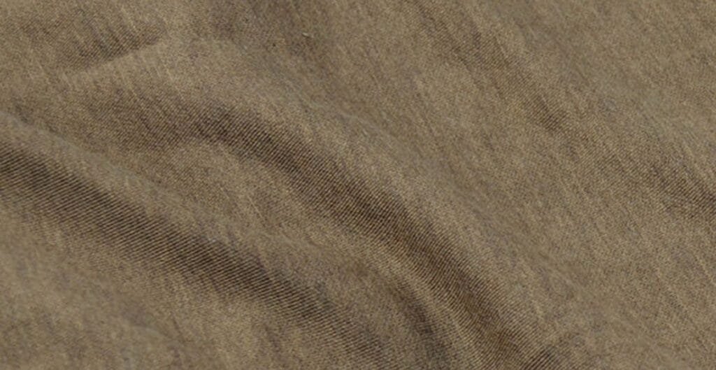 Close-up view of a brown corduroy fabric with fine ridges and natural folds.