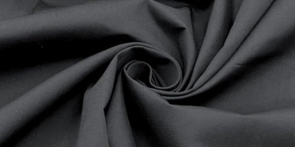 Black fabric with a soft texture, gathered in a spiral pattern.