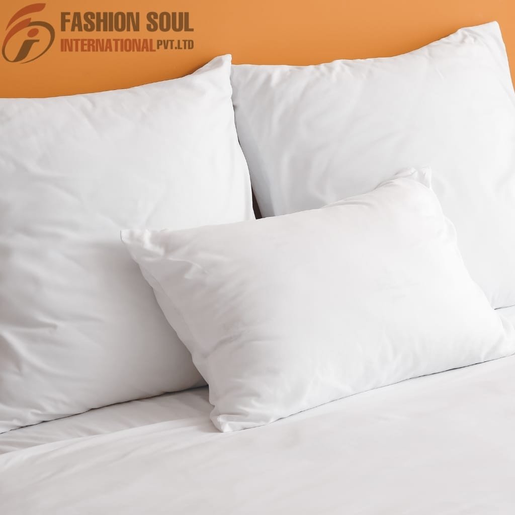 A neatly made bed with three white pillows arranged against an orange wall, with the "Fashion Soul International Pvt. Ltd" logo in the top left corner.