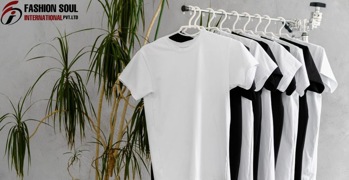 A row of white and black T-shirts hanging on a white clothing rack, with a green plant and a gray wall in the background. The top left corner features the logo "Fashion Soul International Pvt. Ltd."
