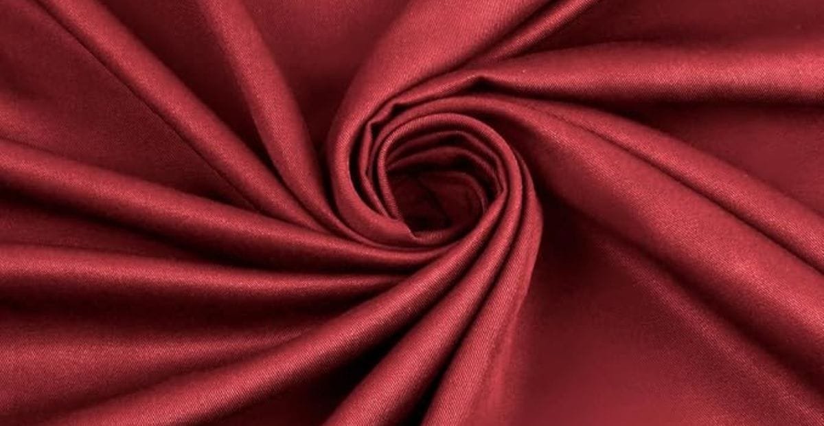 Close-up of red satin fabric arranged in a spiral pattern.