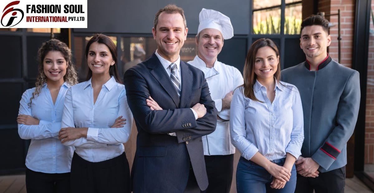 A diverse group of professionally dressed individuals, including a chef, standing outdoors in front of a modern building, smiling confidently.