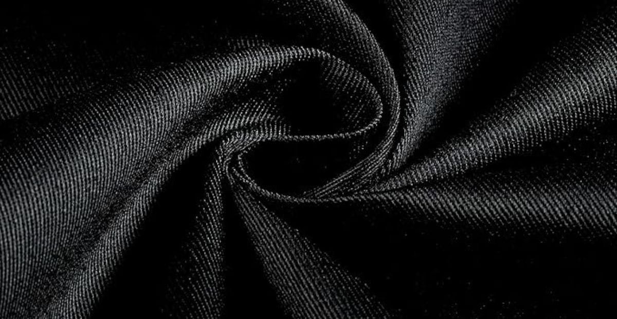 Close-up of black satin fabric twisted into a swirl, showing its smooth texture and subtle sheen.