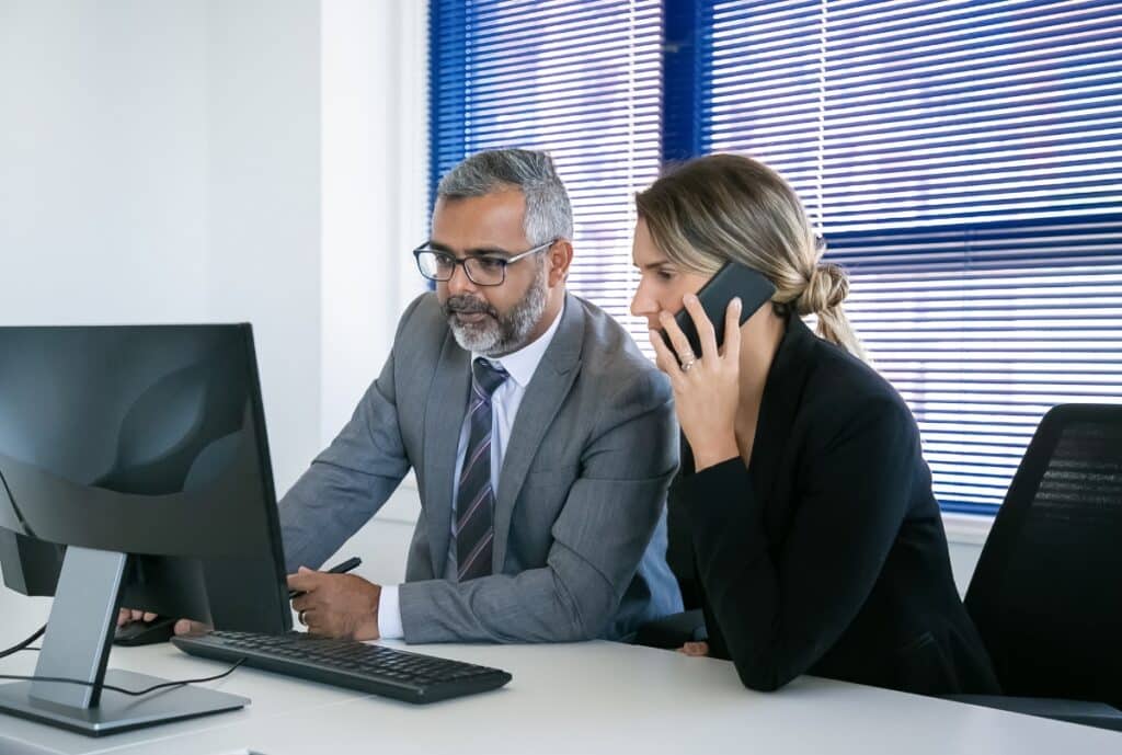Customer support representative assisting a client with consultation services via phone and computer.