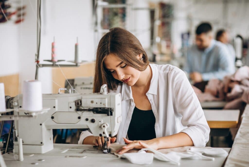 A diverse group of women wearing stylish and functional workwear, collaborating in a modern manufacturing setting.