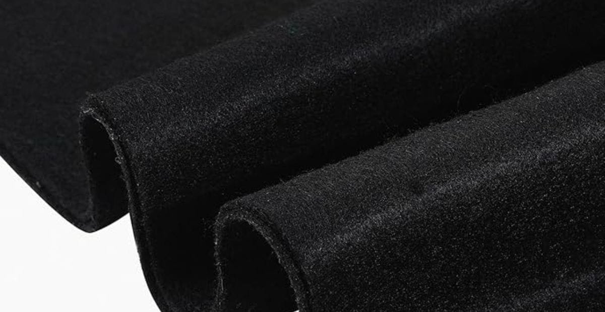 Close-up of folded black velvet fabric with a soft and plush texture.