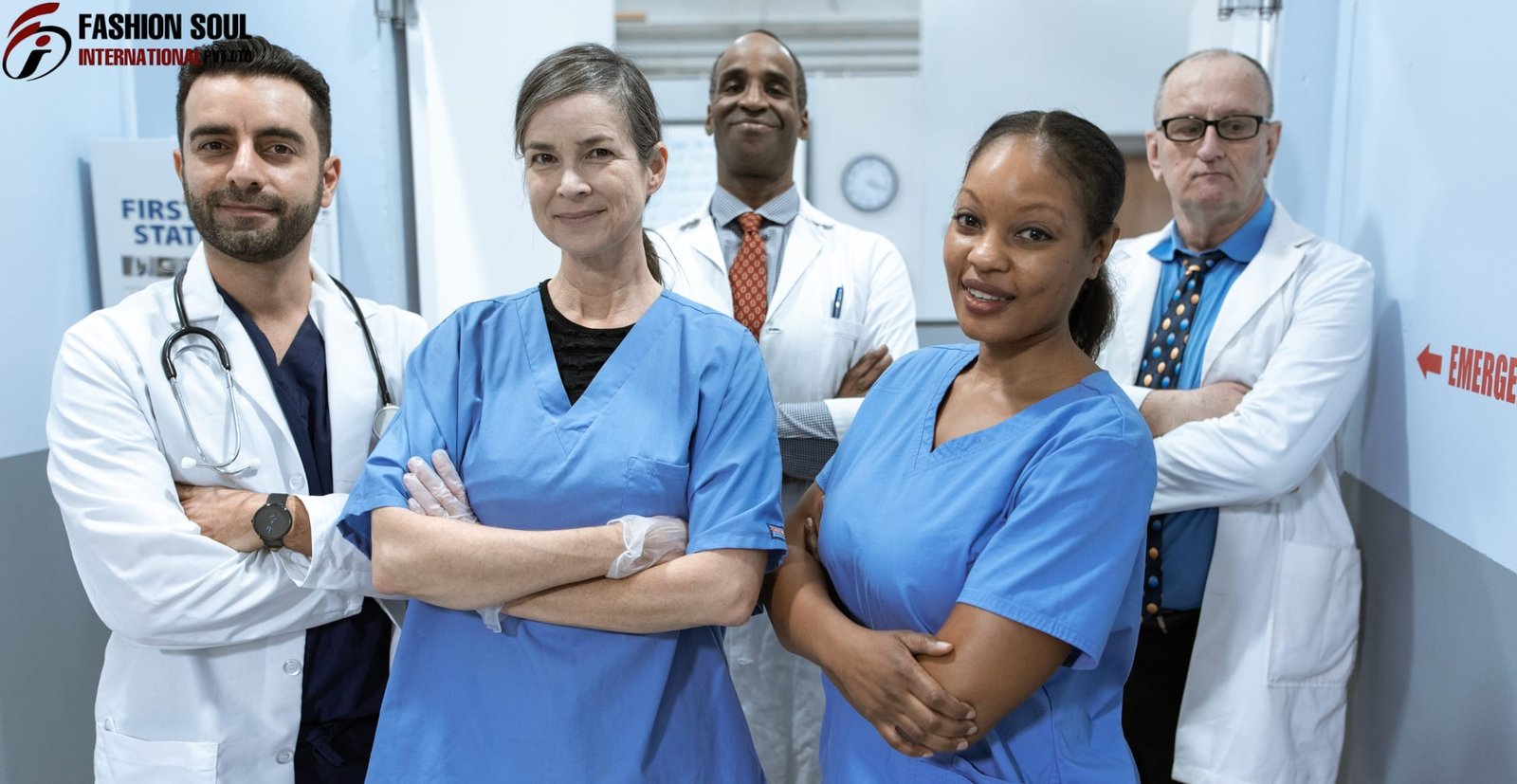 A diverse group of five healthcare professionals, including doctors and nurses, standing confidently in a hospital corridor, dressed in medical scrubs and lab coats.