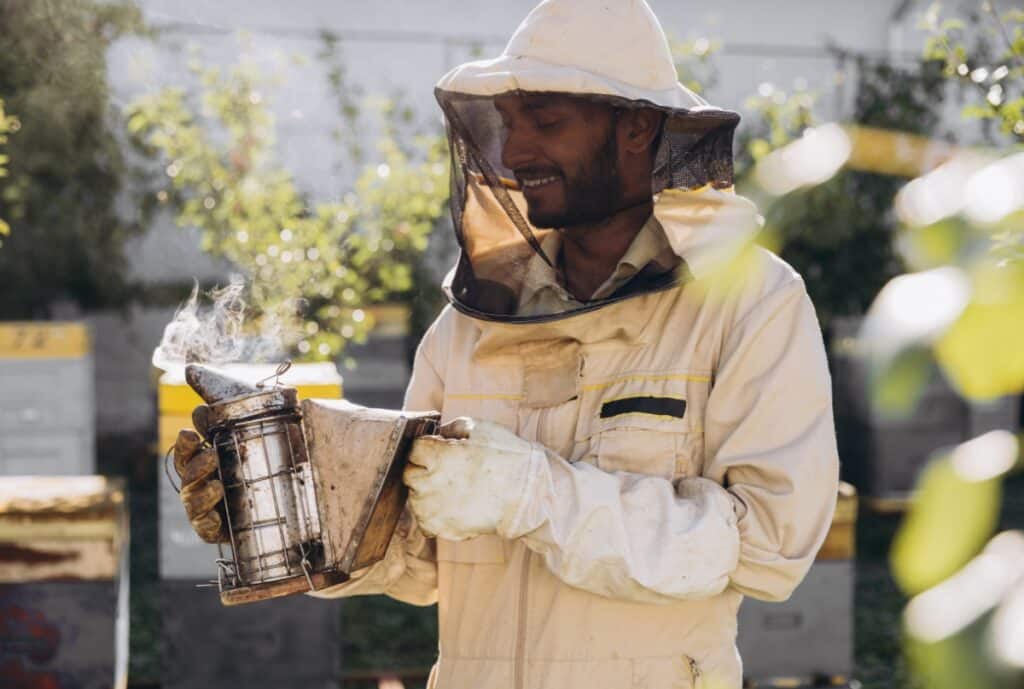 Beekeeper suit in protective white fabric with veil and gloves, displayed on a retailer’s UK storefront.