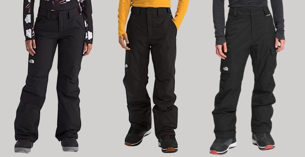 A pair of cargo insulated pants shown in an outdoor setting, featuring multiple cargo pockets, reinforced knees, and a thick, thermally lined interior. The pants are designed for warmth and mobility, with rugged fabric and a visible waist belt for secure fit.