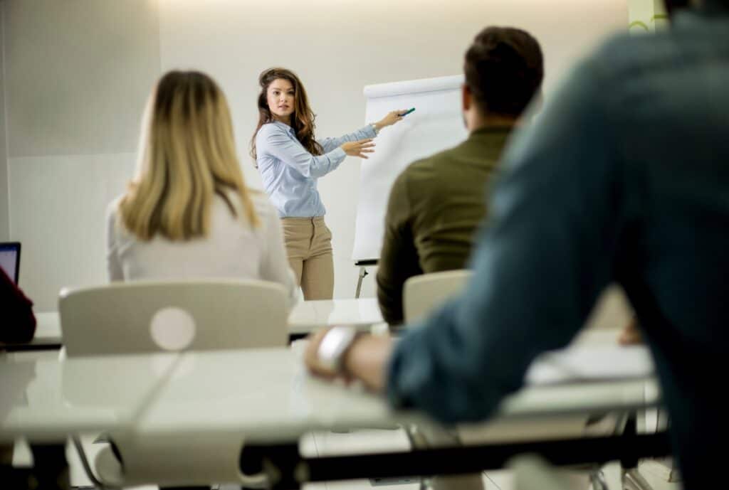 Instructor leading a training session with a group of adults in a classroom setting.