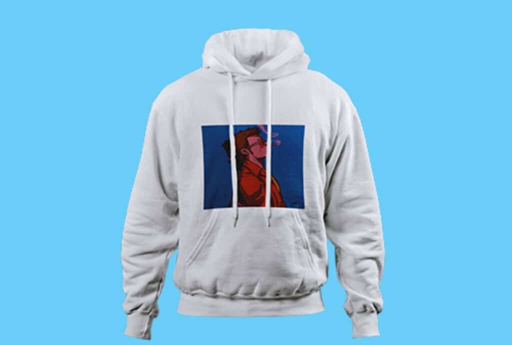 "Designer seated at a workstation sketching an oversized hoodie with bold branding, featuring a relaxed silhouette, large front pocket, and branded color palette."
