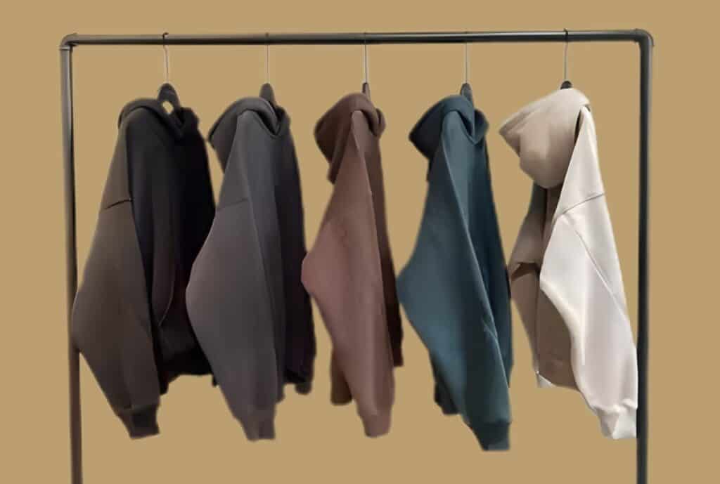 Close-up of an oversized hoodie draped on a mannequin, highlighting long body length, dropped shoulders, and wide sleeves.