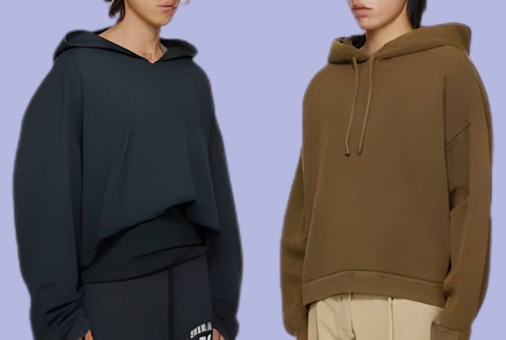 Person wearing an oversized hoodie layered over a fitted t-shirt and slim jeans, sneakers, and a crossbody bag, posing on an urban street.