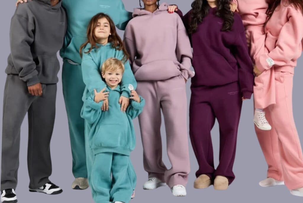 A large selection of oversized hoodies displayed on racks and tables in a bright, modern showroom, with a US flag subtly incorporated to emphasize domestic sourcing.