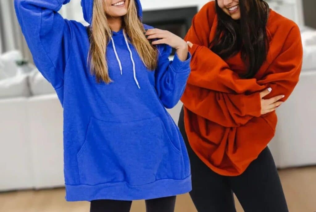 A close-up shot of an oversized hoodie showing extra-wide sleeves and a roomy torso, illustrating the relaxed fit.
