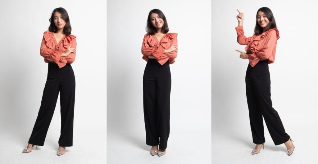 A woman wearing a stylish blouse and high-waisted pants, perfect clothes for short-waisted women