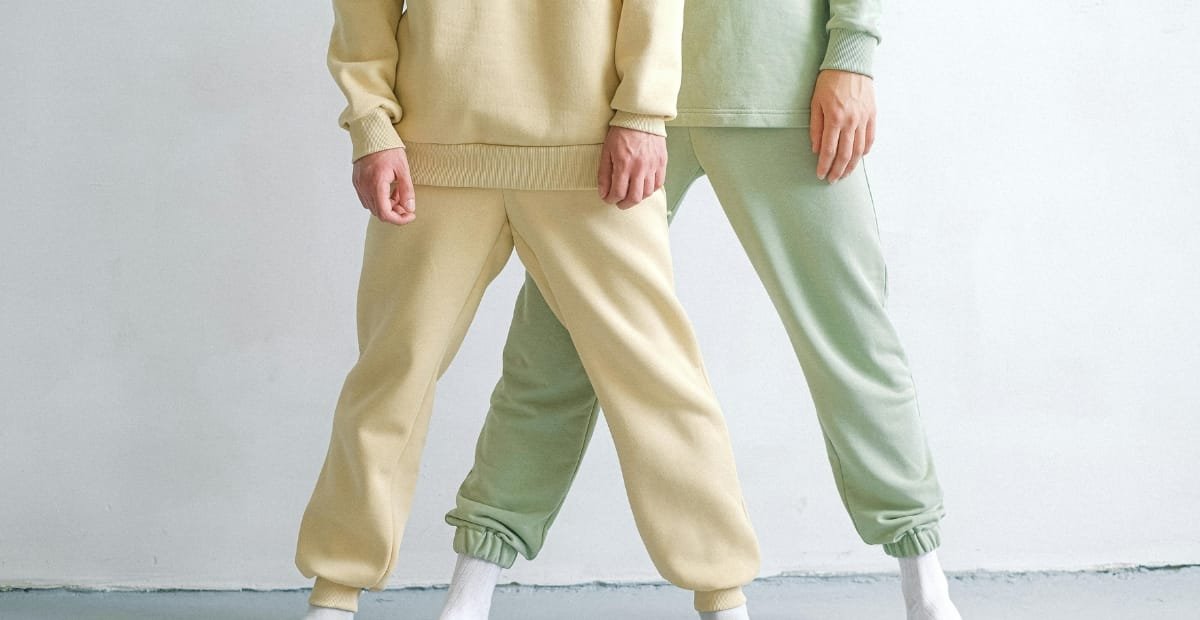Two people wearing pastel Just My Size sweatpants in soft beige and mint colors, showing a relaxed and cozy fit.
