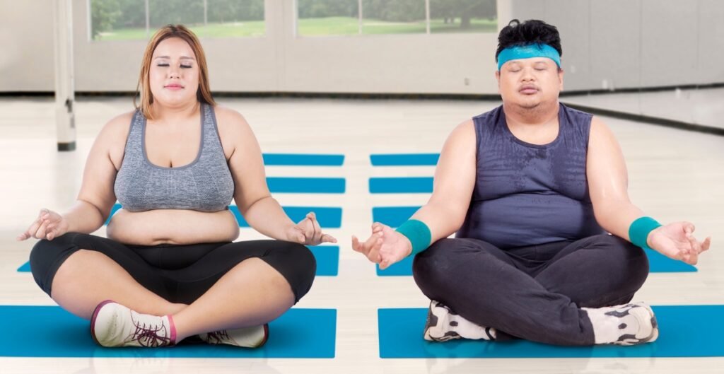 A plus-size woman and man practicing yoga in plus size gym pants, focusing on their fitness in a calm, supportive environment