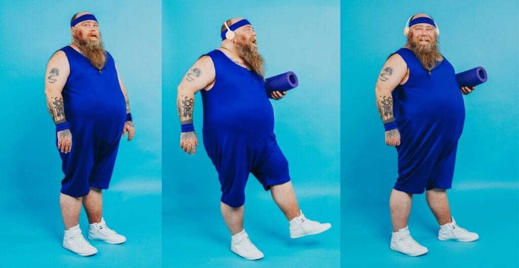 Person in blue activewear, including plus size yoga shorts, stretching with a yoga mat