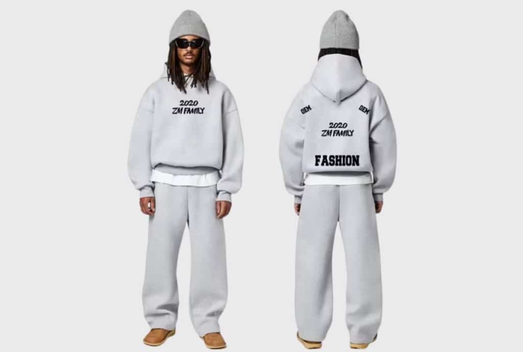 A line of coordinating custom embroidered sweatsuits displayed on hangers and mannequins, featuring varied colors, fonts, and logo placements for corporate and team branding.