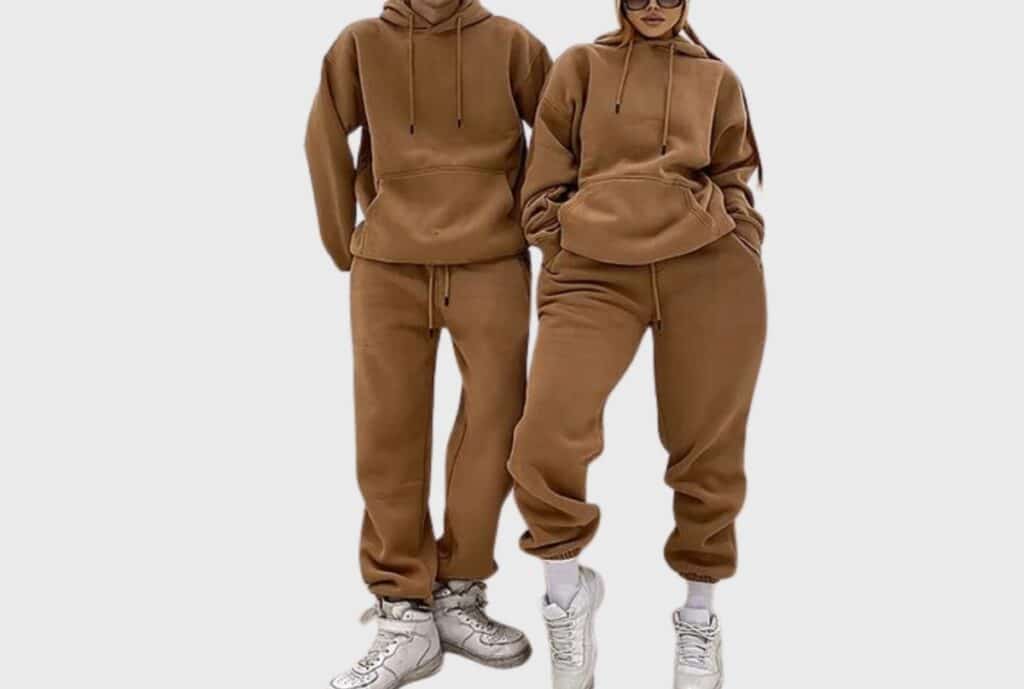 "Heavy-weight cotton sweatsuits on display in a warehouse, stacked in rows with USA supplier signage in the background."