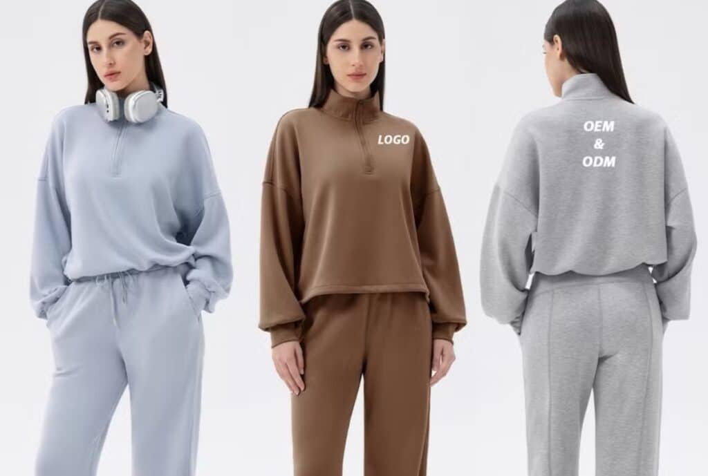“Group of American-made sweatshirts and sweatpants laid out on a table, illustrating cost and lead time considerations for a USA-sourced sweatsuit supplier.”